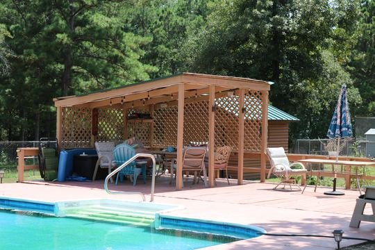 Wooden pool deck, pergola, and patio seating